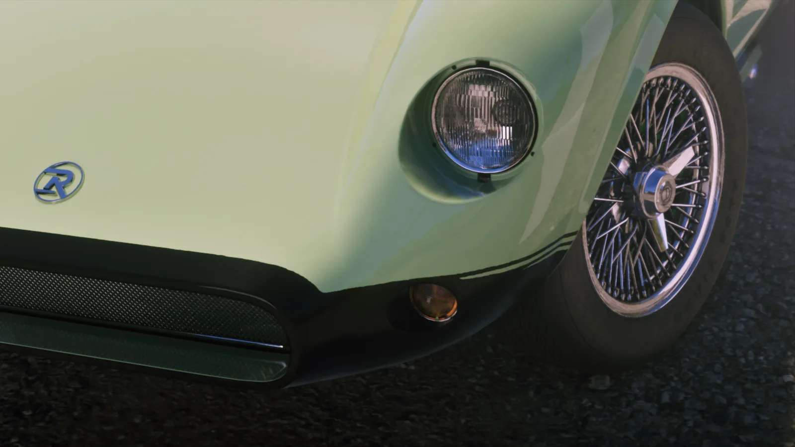 Front corner detail of a pale green classic sports car — a round headlight, a chrome wire-spoke wheel and a blue R roundel badge on the nose.