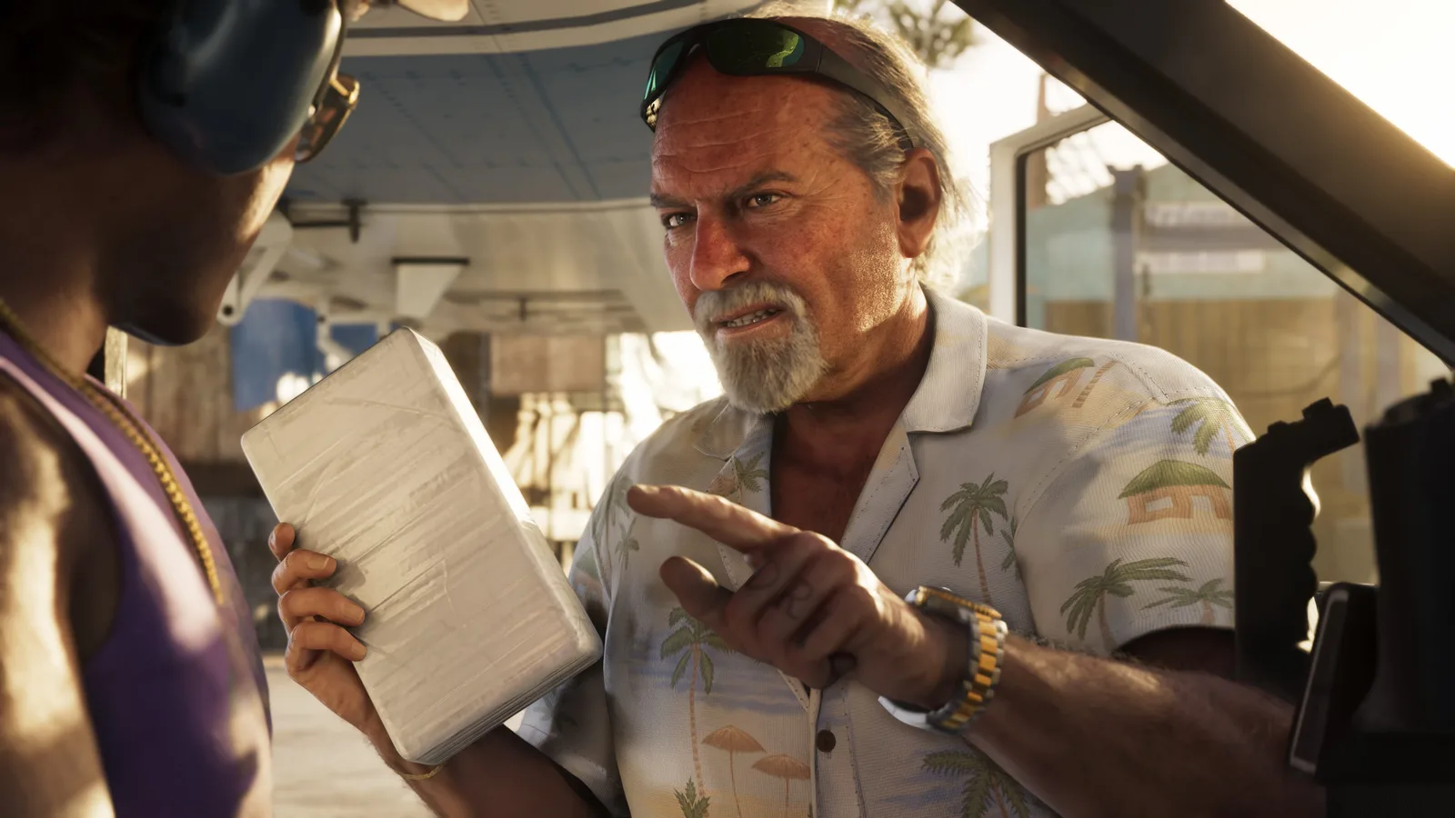 Brian Heder in a palm-print shirt with sunglasses pushed up on his head, gesturing as he talks to a man holding a large shrink-wrapped white brick, a sunlit boatyard behind them.