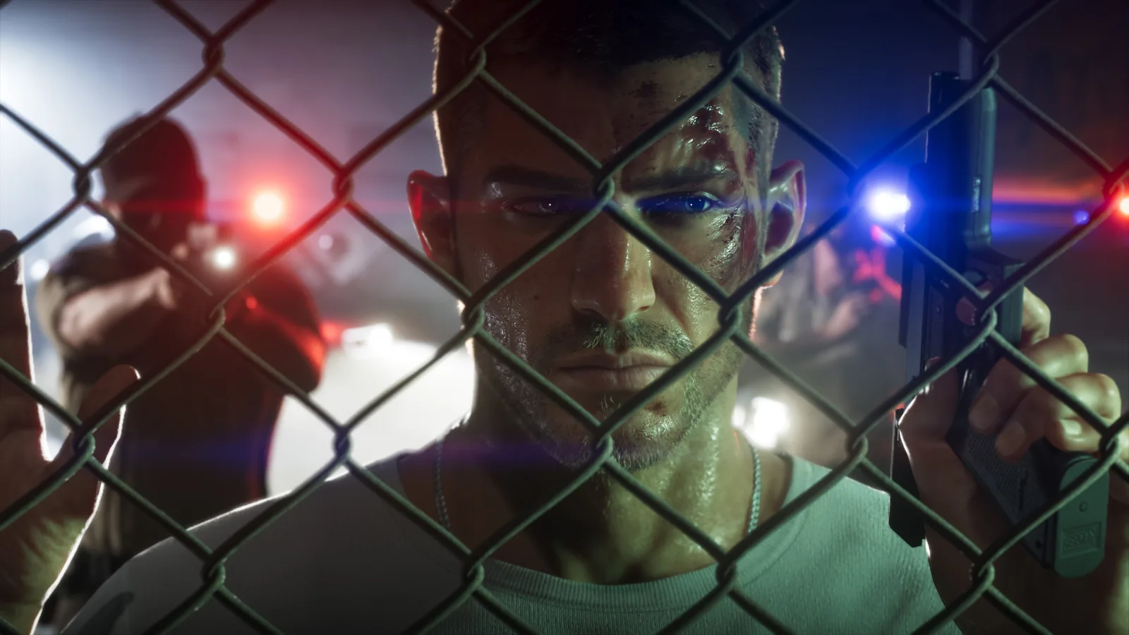 A bruised and bloodied Jason Duval pressed back against a chain-link fence holding a pistol, red and blue lights and an officer aiming through the mesh behind him.