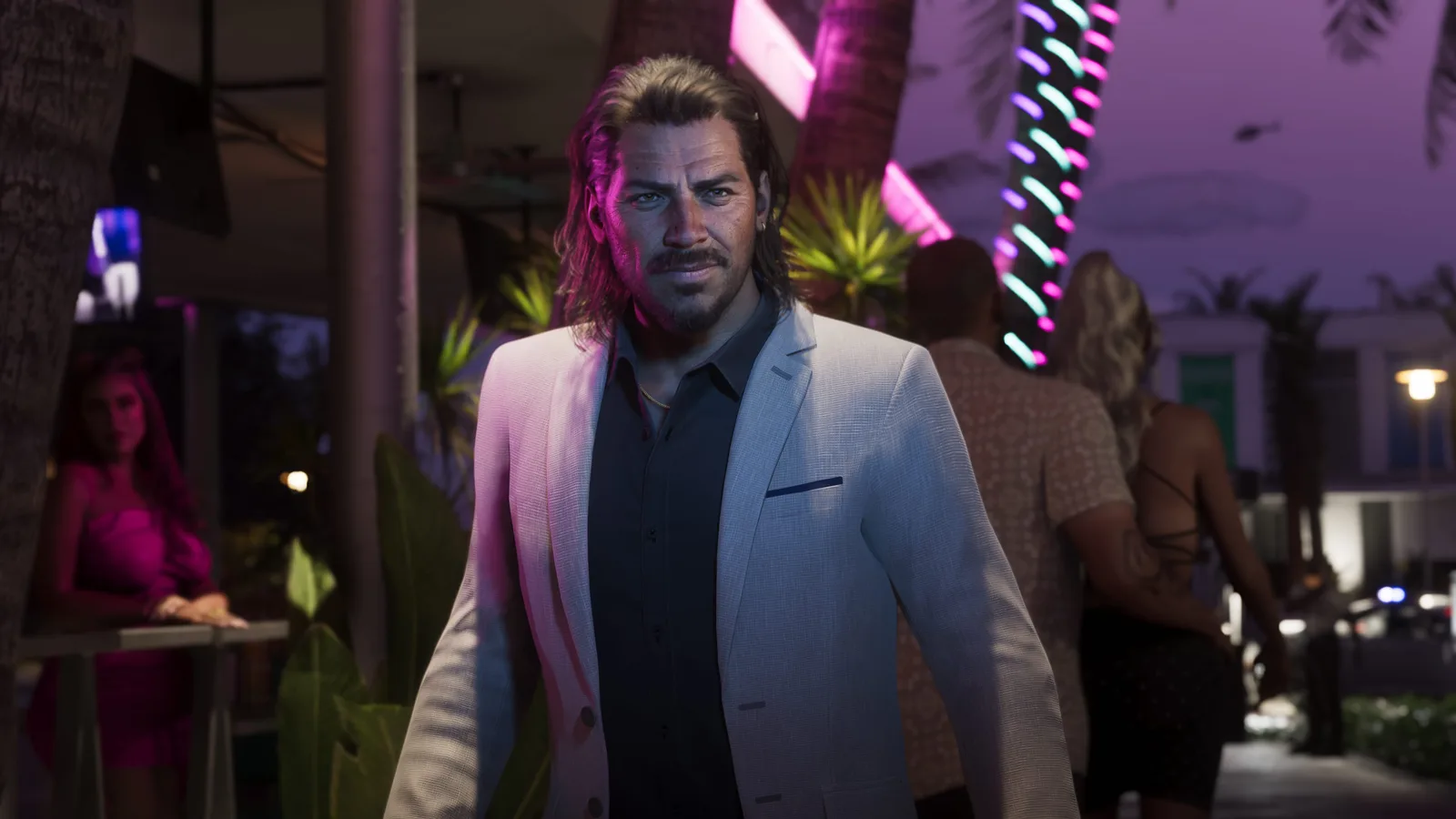 Raul Bautista walking towards the camera at night in a pale linen blazer over a dark shirt, neon-lit palms and bar-goers behind him.
