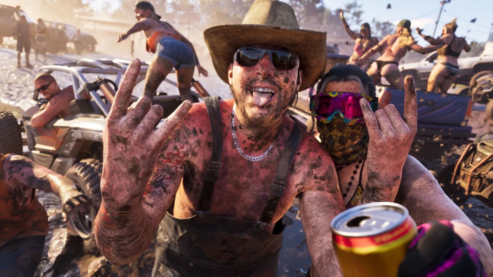A mud-covered man in dungarees and a straw hat grinning at the camera with both hands raised, surrounded by quad bikes, pickups and mud-spattered revellers at an off-road party.
