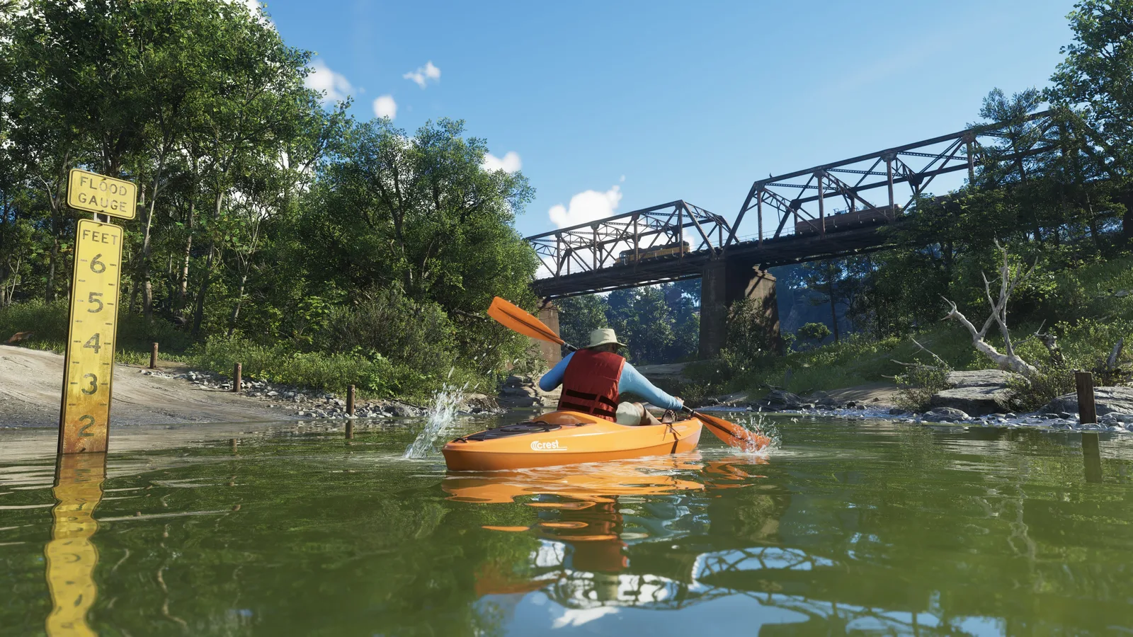 A paddler in a red life vest and sun hat in an orange kayak on a green river, a yellow flood-gauge marker post in the foreground and a steel truss railway bridge beyond.