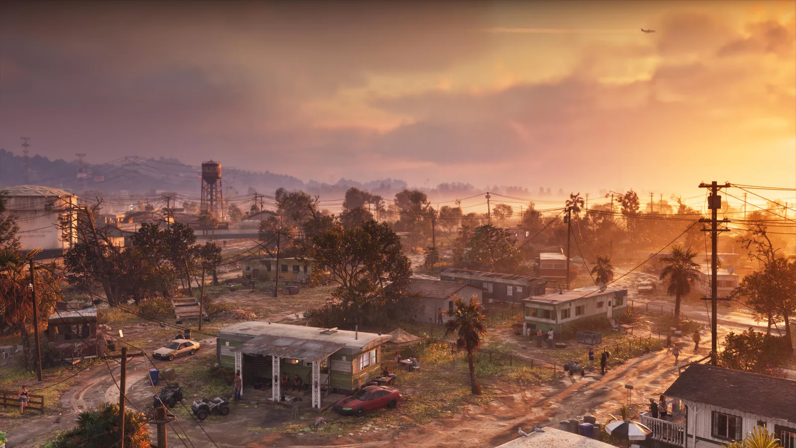 A hazy sunrise over a low-lying neighbourhood of trailers, shacks and power lines, a water tower on the skyline and residents out on the dirt lots.