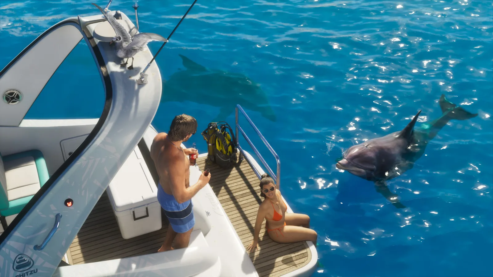 Looking down onto the Squalo's teak swim platform — a man in swim shorts standing with a drink and a woman in an orange bikini sitting at the edge, scuba gear stowed beside them and two dolphins in the clear blue water alongside.