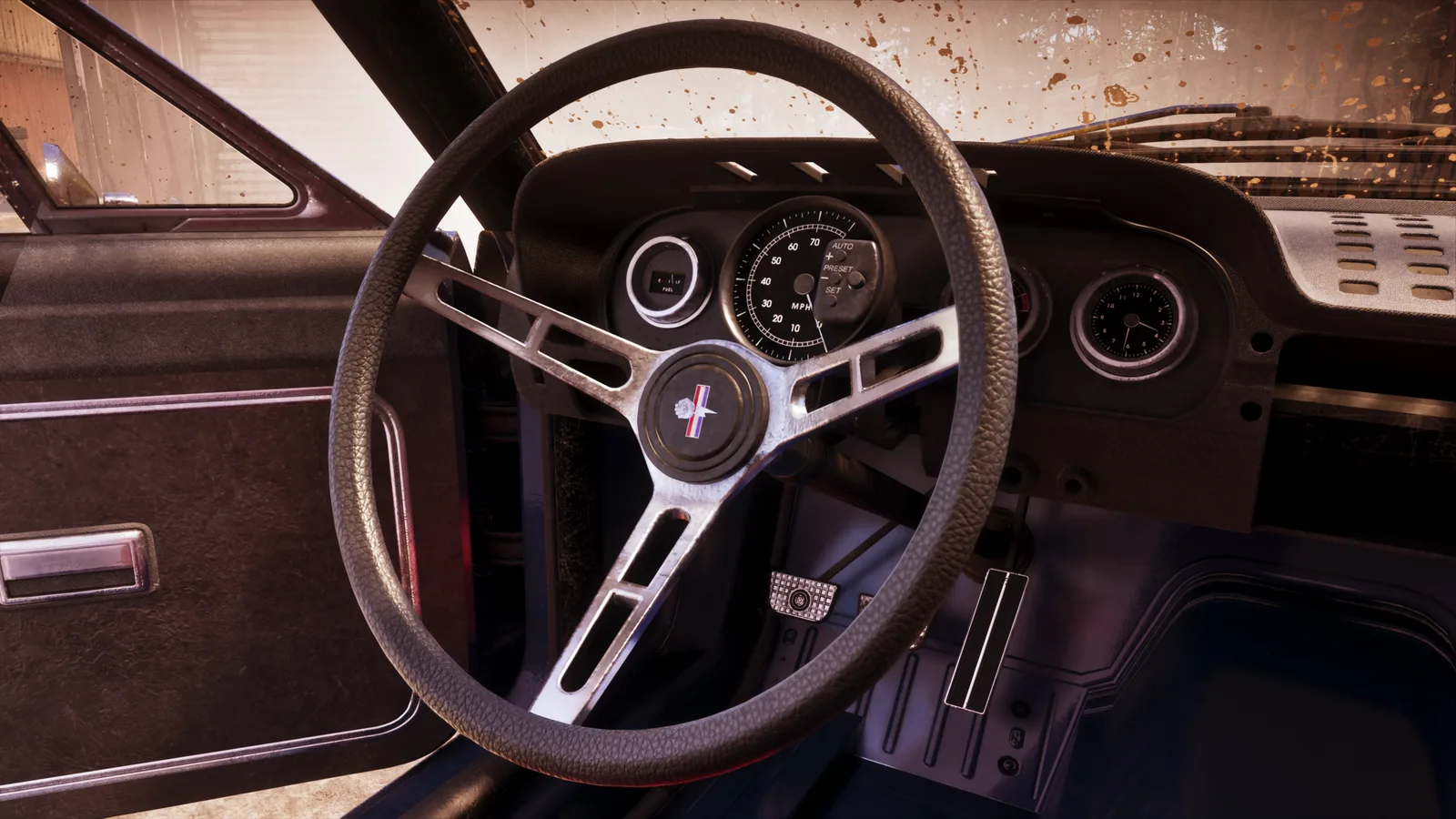 The buggy's cabin — a worn three-spoke steering wheel, a simple round MPH dial and a clock on a dusty dashboard, mud spattered across the windscreen.